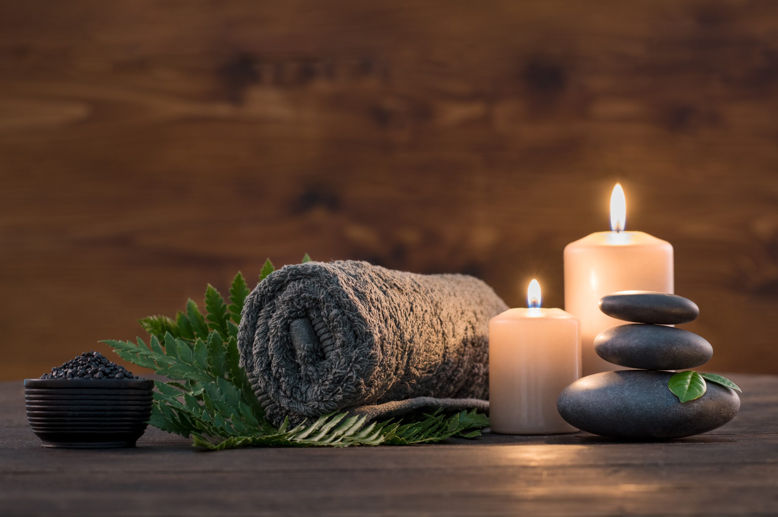 Towel,On,Fern,With,Candles,And,Black,Hot,Stone,On